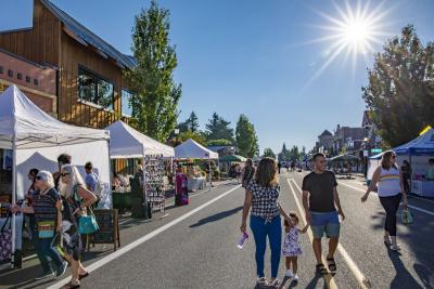 A family in downtown Troutdale under a sunny sky during First Friday