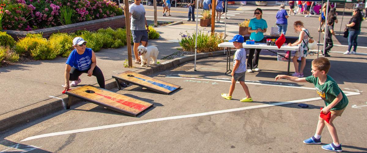 A boy plays corn hole at the First Friday Kid Zone in downtown Troutdale