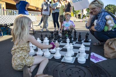 Kids play giant chess at the First Friday Kid Zone 