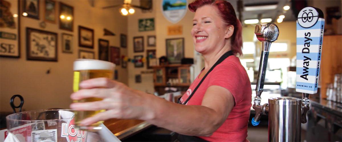 Woman serves a beer at Lolo's Boss Pizza in Troutdale