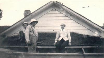 Margaret Ashworth Knarr sits atop the porch roof of her house during the flood of 1948. Photo courtesy of THS