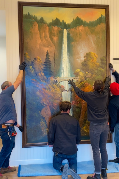 A crew hangs the historic painting of Multnomah Falls in Troutdale's the Gateway to the Gorge Visitor Center