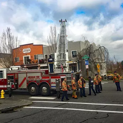 Gresham Fire Department crew trains with a ladder truck in downtown Troutdale