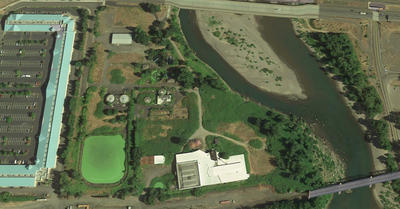 Aerial view of The Confluence site in July 2018. The green ''pond'' is part of the city's former sewage treatment facility.