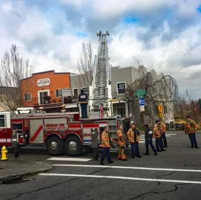 Gresham Fire Department crew trains with a ladder truck in downtown Troutdale