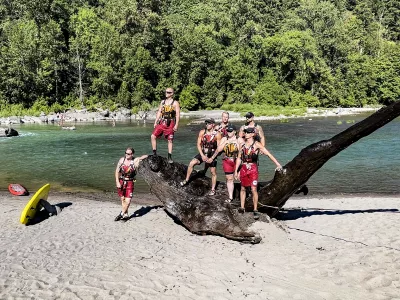 AMR lifeguards pose with the large snag that was removed from the Sandy River
