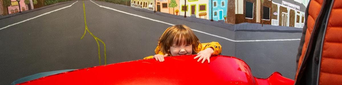 Child smiles as she hides at Troutdale Windy Wonderland
