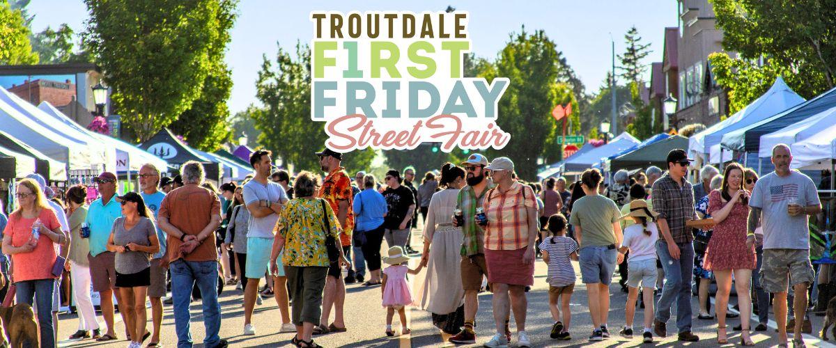 People walk along Historic Columbia River Highway in downtown Troutdale during First Friday