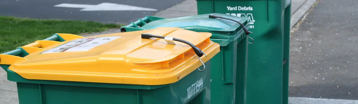 Yellow and green garbage and recycling rolling carts