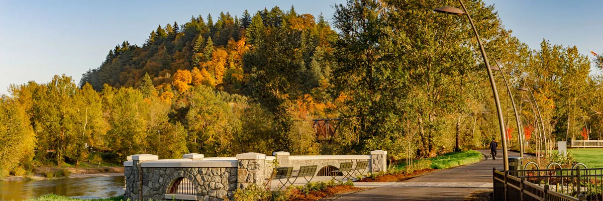 Broughton Bluff, covered in fall colors, rises above the Sandy River and the observation deck at Sharon Nesbit Heritage Park